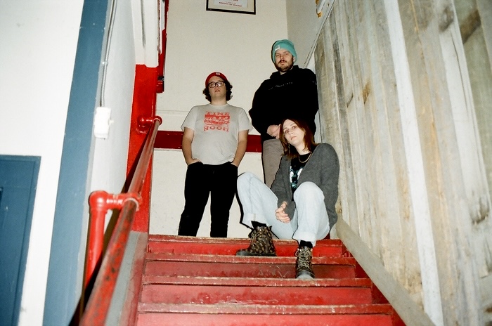 Photo of Malamiko members sitting in a stairwell.