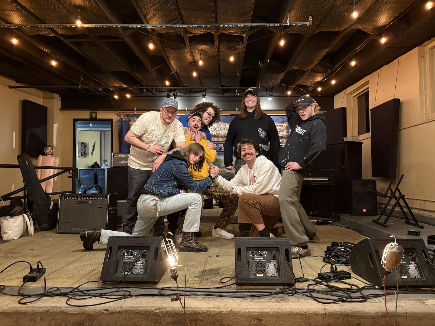 malamiko and hey, ily! posing onstage after our final show in milwaukee. daisy and caleb are doing the hardcore kid handshake pose, and everyone else is acting silly behind them.